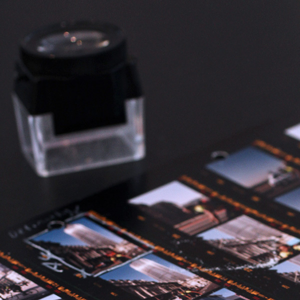 Picture is of a 35mm colour film contact sheet with a magnifying loupe. The loupe is traditionally used for checking whether the negs are sharp